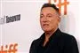 bruce springsteen står foran væg med reklamer