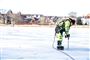 Mand måler tykkelsen på is.