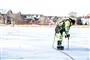 Mand måler tykkelsen på is.