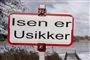 skilt med "isen er usikker" ved sø