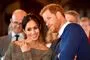 Nærbillede af Meghan og Harry hvor de hvisker og smiler. 