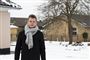 En fyr i frakke, halstørklæde stående i sneen