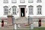 Dronning Margrethe vinker ud ad døren på Fredensborg