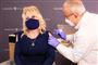 Dolly Parton med sort mundbind får en vaccine