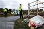 Blomster ved indkørsel, politimand holder vagt