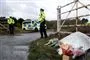 Blomster ved indkørsel, politimand holder vagt