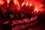 demonstranter med romerlys og banner med påskriften "Sortklædt modstand" 