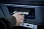 En mand hiver hundrede kroner ud af en pengeautomat. 