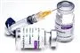 vaccineglas fra astra-zeneca og kanyle ligger på bord
