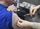 En person bliver stukket i skulderen med vaccine. 