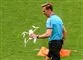 fodbolddommer går med drone og flag i hænderne
