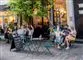 folk sidder udenfor på fortovscafe
