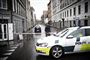 politibil holder på gade med afspærringsbånd