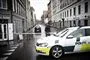 politibil holder på gade med afspærringsbånd