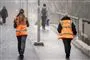 to personer i orange veste går over bro