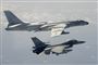 Et F-16 fly og et kinesisk bombefly ved siden af hinanden