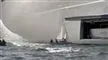 En lille båd vædrer en megayacht
