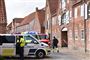 Politi-og brandbiler foran hus.