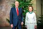 Kong Harald og Dronning Sonja står foran juletræ