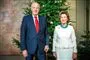 Kong Harald og Dronning Sonja står foran juletræ