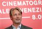 mads mikkelsen står foran rød væg