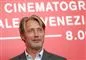 mads mikkelsen står foran rød væg