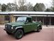 En grøn Land Rover med lad