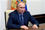 vladimir putin sidder i mørk jakke og blå skjorte 