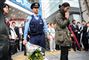 En politimand holder en buket, der skal lægges på gaden i Akihabara, hvor 17 tilfældige japanere på tre minutter i går blev stukket ned. Foto: AP/ Katsumi Kasahara