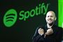 En glad mand foran Spotify-logo