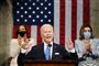 Biden taler med to kvinder i baggrunden og det amerikanske flag hængnede ned