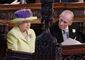 Dronning Elizabeth og prins Philip sidder ved siden af hinanden på en kirkebænk. Han kigger hen mod hende, hun ser lige frem for sig.