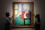 Et farverigt maleri af Picasso holdes i hver sin ramme af to kvinder