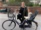 En smilende dame ved sin cykel