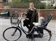 En smilende dame ved sin cykel
