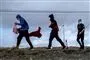 Migranter løber på en strand