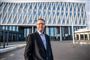 mand i jakkesæt står foran rådhus
