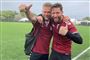 to smilende mænd står i fodboldtøj