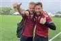 to smilende mænd står i fodboldtøj