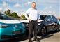 En smilende mand ved elektriske VW-biler
