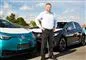En smilende mand ved elektriske VW-biler