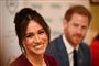 Meghan Markle med et stort smil og Harry i baggrunden.