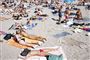 folk ligger og solbader på strand