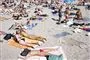 folk ligger og solbader på strand