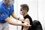 mand får vaccination med et stik i skulderen