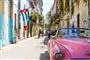 en gammel pink Chevrolet cabriolet i en gade på Cuba