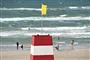 Et livreddertårn med gult flag på en strand