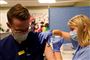 En mand bliver vaccineret af en kvindelig sygeplejerske