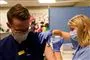 En mand bliver vaccineret af en kvindelig sygeplejerske