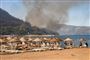 brand i bjerge med strand i forgrunden 